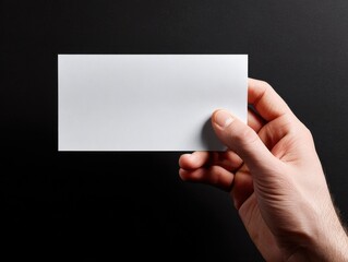 hand holding paper sheet isolated on a black background