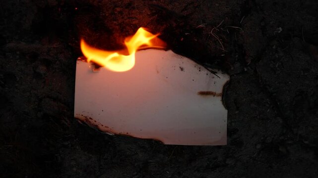 Burning and glowing photo or paper with fire flame and smoke on dark background