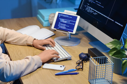Female programmer working with computer at table in office, closeup