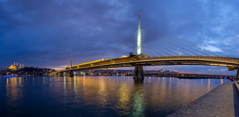 Fototapeta premium Golden Horn ( Halic ) Metro Bridge and historic Suleymaniye Mosque skyline at dramatic dusk