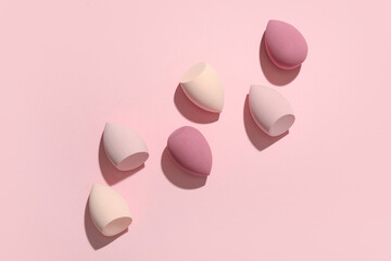 Fototapeta premium Many makeup sponges on pink background
