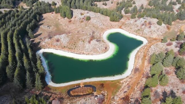 Aerial drone footage of Barouk Lake in Lebanon, a green reservoir bordered by forest and hills. Ideal for travel tourism, nature, environment, and scenic aerial backgrounds