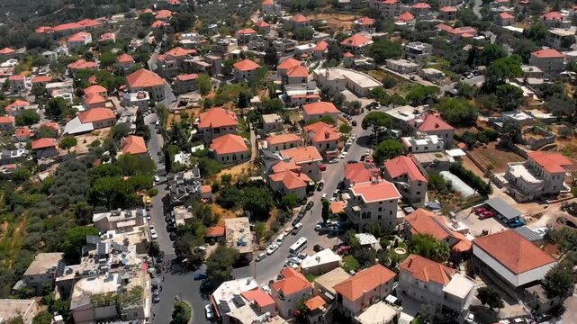 Establishing aerial drone footage of Douma, Lebanon, showcasing mountain village rooftops and greenery for tourism and lifestyle marketing.