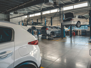 Modern auto repair shop interior with cars on lifts and tools for maintenance © shine.graphics