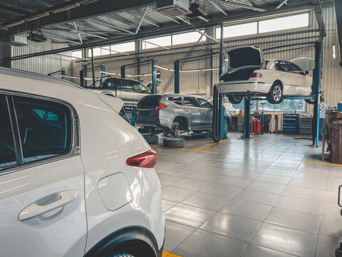Modern auto repair shop with cars on lifts and tools, ready for maintenance