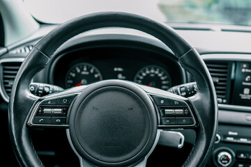 Modern car interior with focus on the steering wheel and dashboard controls