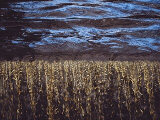 A close-up of water dropping off a weir or waterfall
