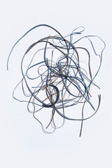 Nest of discarded loose wires on soldi white backdrop