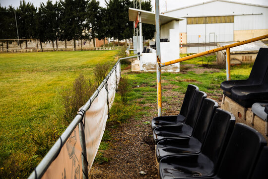 Black plastic stadium seats wet with rain and dirt stains