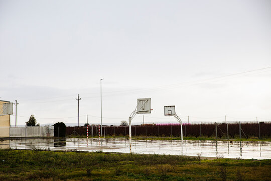 Rustic basketball hoop on empty outdoor court in rural field