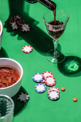 Pouring wine on green table with poker chips © Cavan