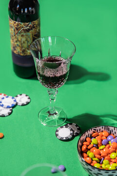Wine glass, chips, and candies on green table