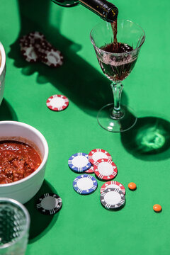 Pouring wine on green table with poker chips