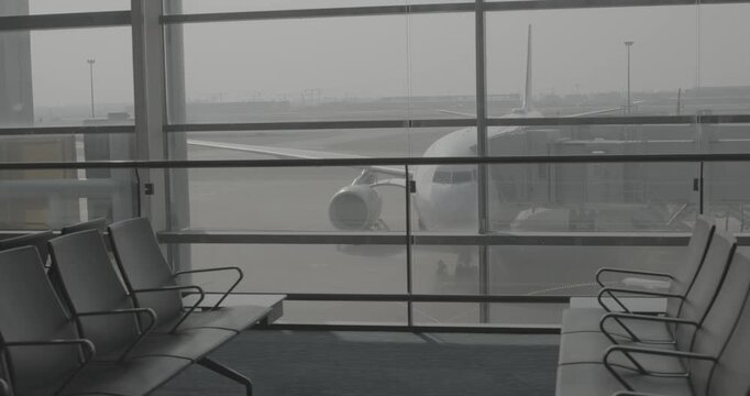 View of airplane parked at the glass terminal gate