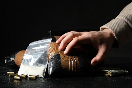 Man with drug packages and money on dark background, closeup