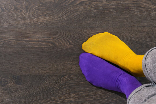 Close up mismatched yellow and purple socks with copy space, World Down Syndrome Day awareness inclusion diversity support concept