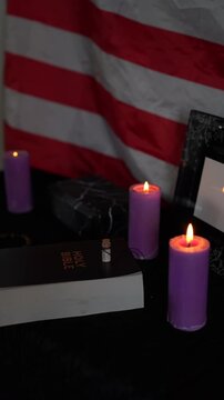     funeral of an American hero, photo frame, candles, a marble urn for ashes, holy bible and spiritual bracelet with black cross