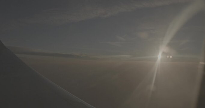 Dramatic sunset with light rays over airplane wing view