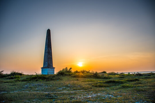 Beautiful Sunset Over a Pristine Tropical Beach with Swaying Palms and Golden Sands in Mannar, Sri Lanka, Featuring the Historic Dutch Colonial Monument Tower