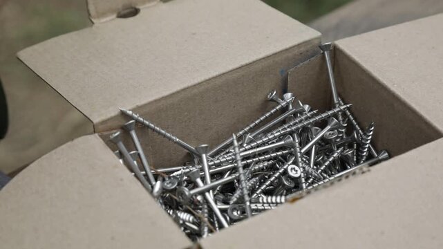 A man selects nails from a box
