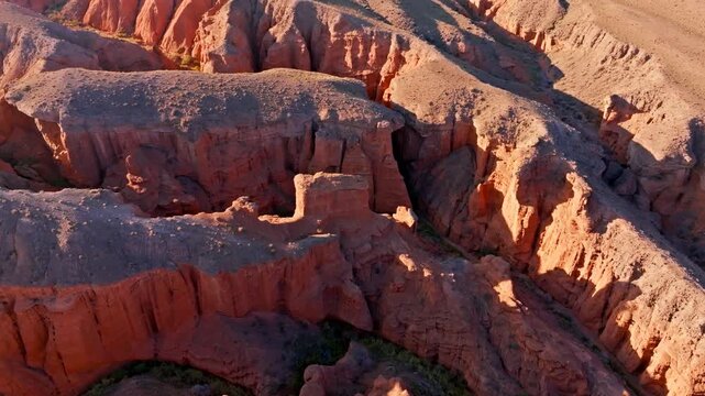 Descending aerial view of eroded sandstone Kok-Moinok Eki canyons in Kyrgyzstan