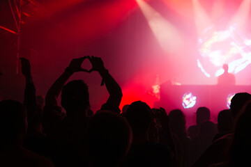Fototapeta premium Cheering crowd with hands raised at concert. Summer and festival vibes