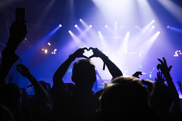Cheering crowd with hands raised at concert. Summer and festival vibes