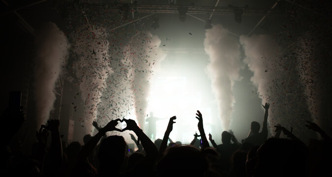 Cheering crowd with hands raised at concert. Summer and festival vibes