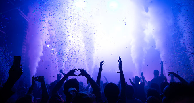 Cheering crowd with hands raised at concert. Summer and festival vibes