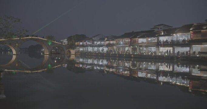 Historic Arched Bridge Over Waterway Reflecting City Lights at Night. Zhujiajiao, Shanghai, China