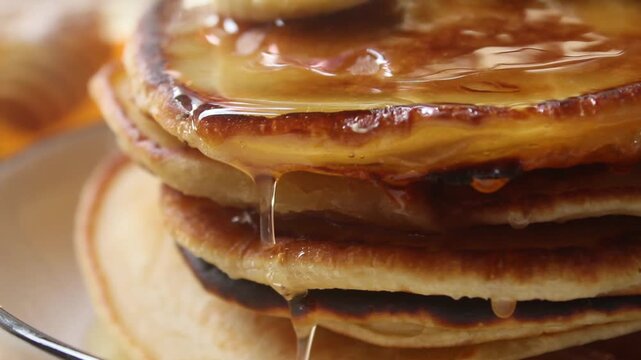 close up of pour honey on top of the pancakes