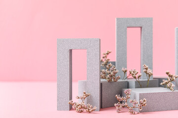 Decorative plaster podiums with gypsophila flowers on pink background