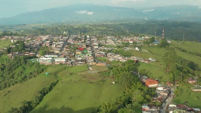 drone flying from balcony to main filandia city in quindio colombia in a sunny day overlooking all the city n the Mountains