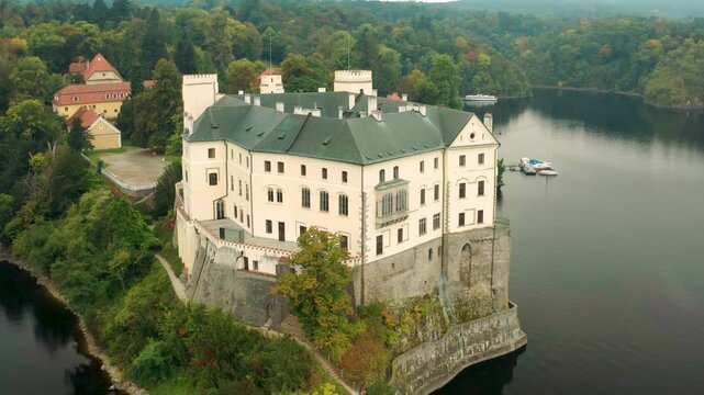 drone flying around est side of castle orlik during the day overloking the entry n main garden, czech republic
