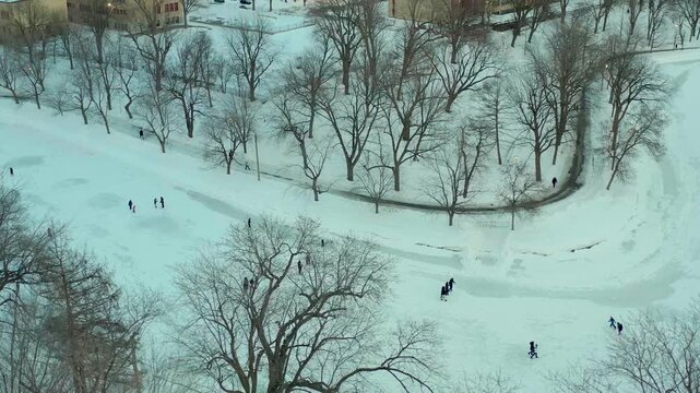 drone overlooking lake inside parc lafontaine in montreal quebec canada n people patin in winter