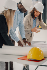 Engineering team collaborating on construction project blueprints