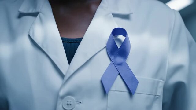 African American Woman doctor wearing white coat with a blue ribbon for support and awareness, medical professional.