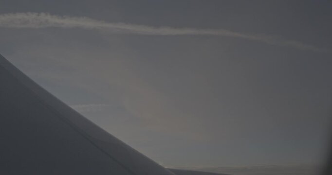 Soft pastel colors of sunset illuminating airplane wing