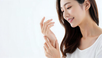 手の甲に触れて肌の潤いを確認して微笑む若い女性