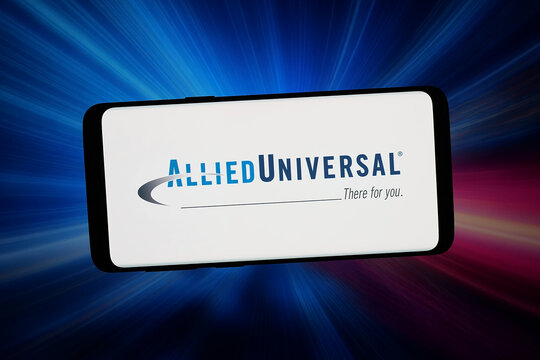 Stuttgart, Germany - 02-16-2026: In this photo illustration, the logo of US private security company Allied Universal is displayed on a smartphone in front of abstract background on computer screen.
