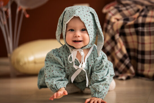 Baby in bunny hat crawling on the floor, celebrating first birthday