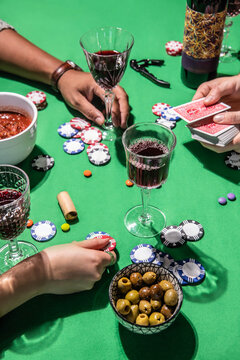 People playing poker and gambling with wine chips and snacks