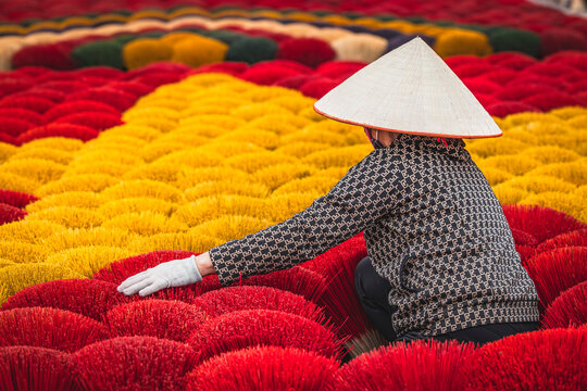 working on drying red incense sticks on the outskirts of Hanoi