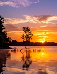 Obraz premium Golden Hour Reflection - Serene Lake Landscape at Sunset.