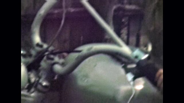 Little boy playing on motorcycle in countryside street. Cute small kid imagines being rider, enjoying active play leisure in nature. Happy childhood. Old film. Archival retro 1970s. Vintage archive