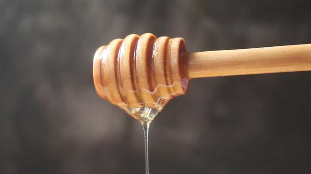 honey dripping from a wooden dipper