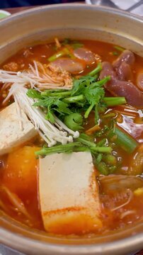 Boiling Korean spicy fish roe soup (Al-tang) with fresh pollack roe and vegetables in a stone pot