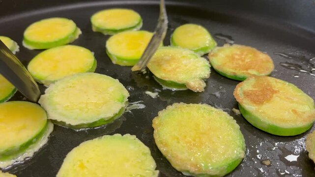 Cooking healthy vegetarian Korean zucchini fritters in a hot pan, traditional festive food