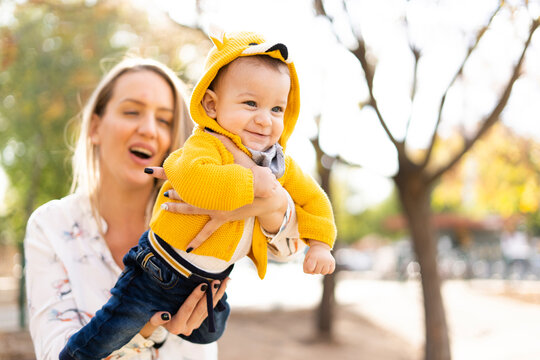 Happy mother playing with baby boy in a park