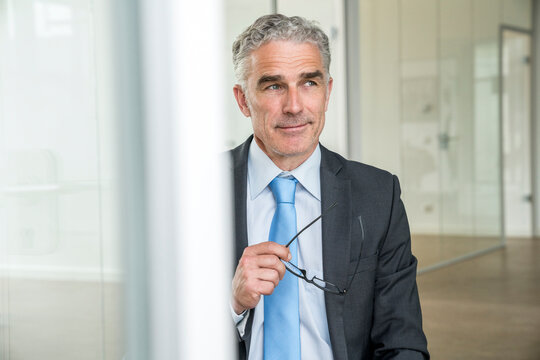 Portrait of a mature businessman, holding glasses